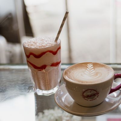Cremiger Milchschaum auf unvergesslich Kaffeevariation und fruchtiger Milchshake
